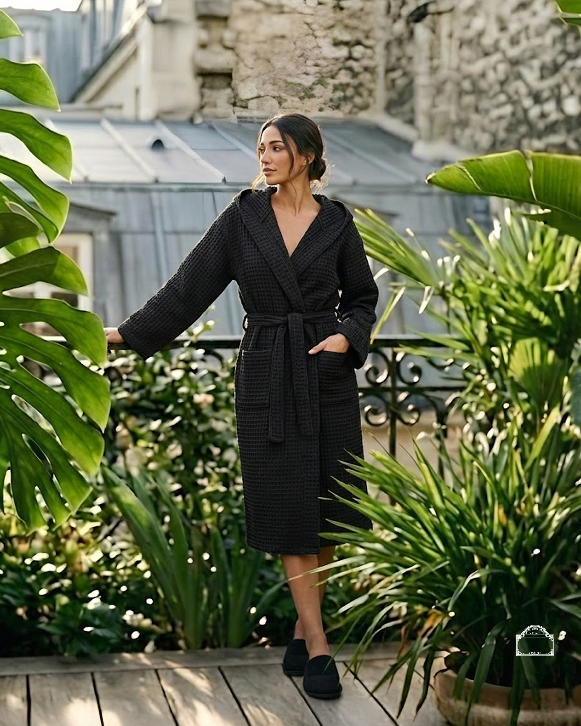 Woman wearing black waffle bathrobe on Parisian terrace