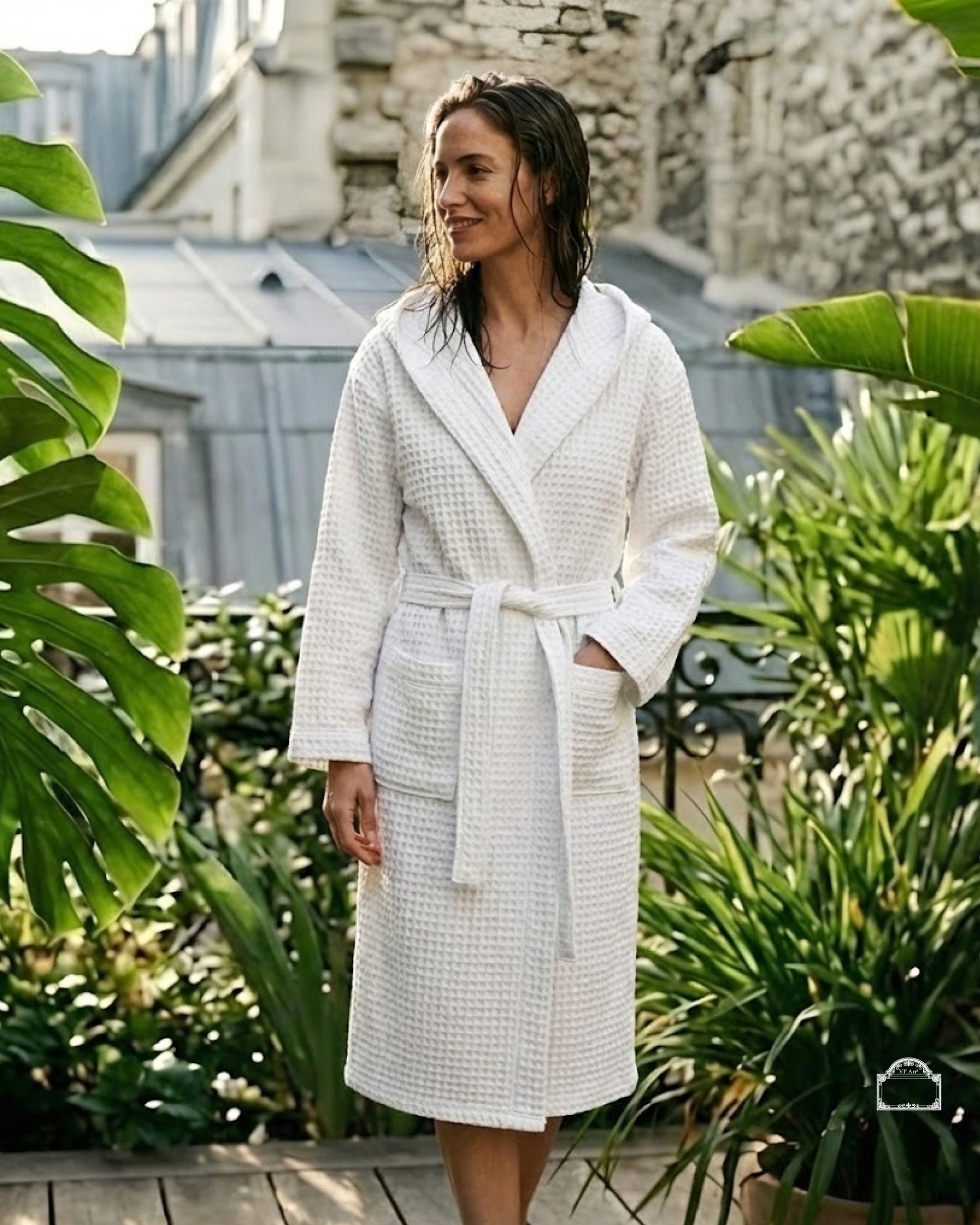 Woman wearing white waffle bathrobe bathrobe in Parisian courtyard